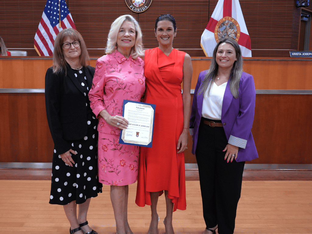 Commissioner Arnold and others stand with proclamation