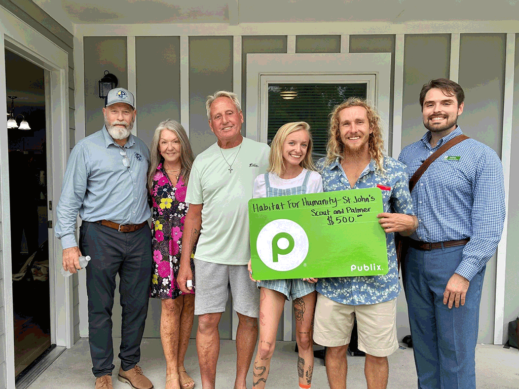 Habitat for Humanity recipients posting for group photo with new home in background