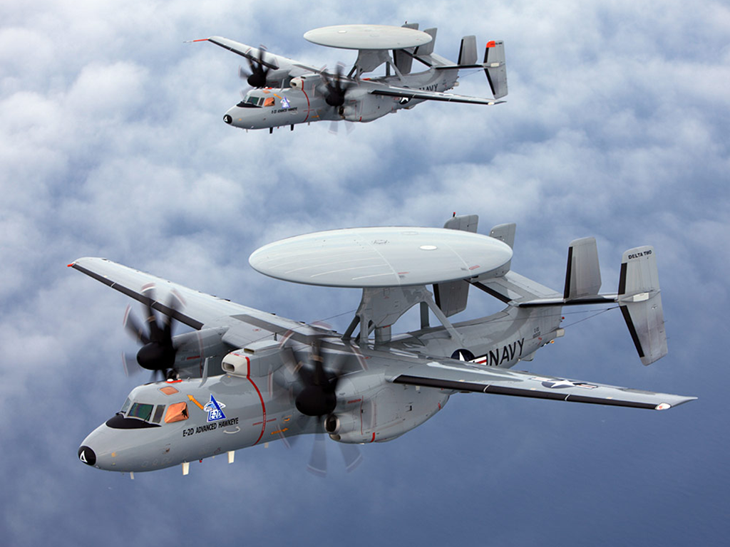 Two Northrop Grumman’s E-2D Advanced Hawkeye aircrafts flying above puffy clouds.